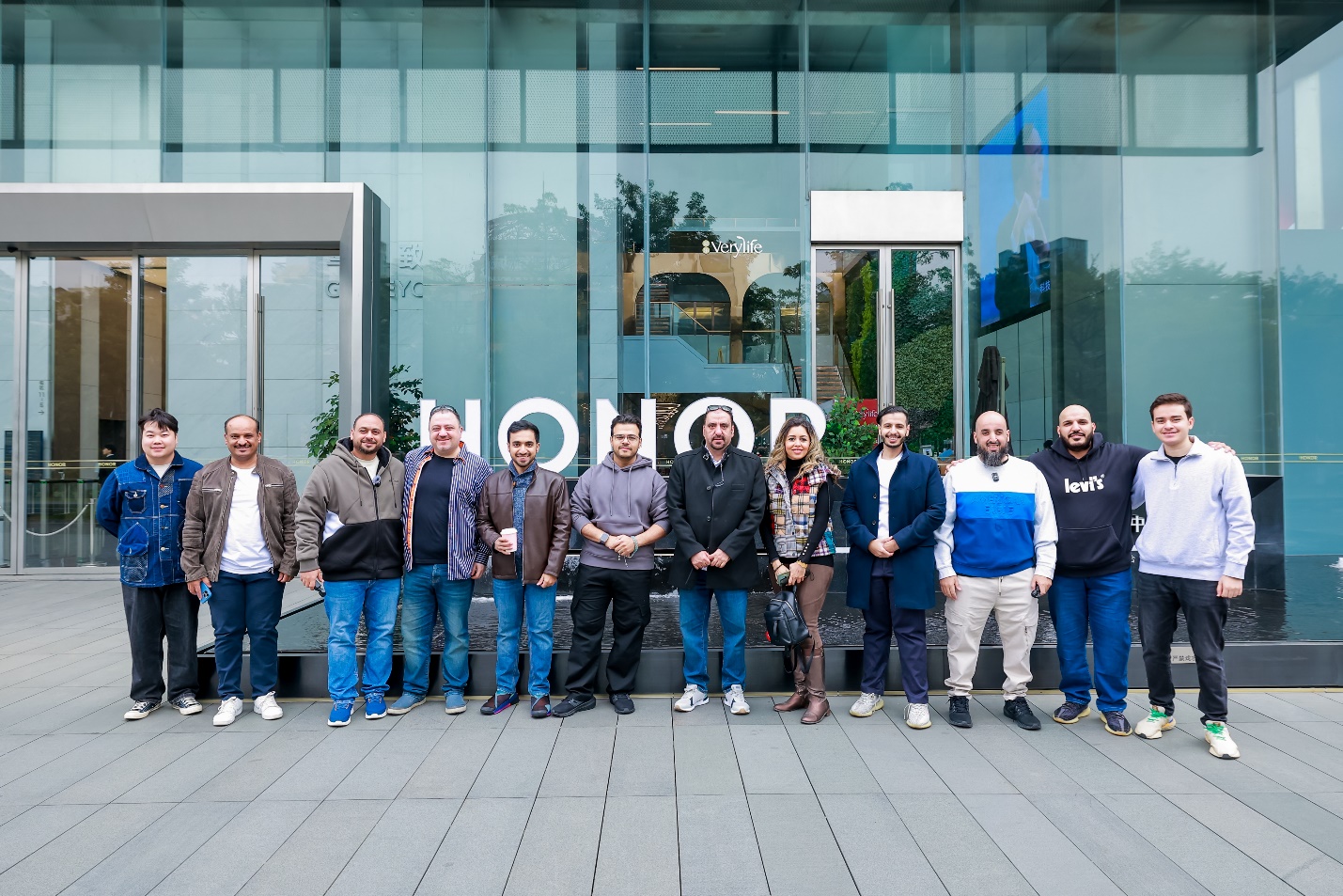 A group of men standing in front of a building

Description automatically generated